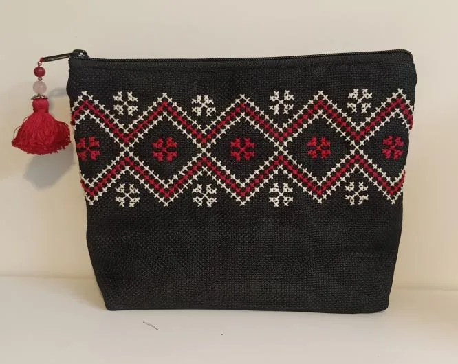 Black pouch with a red and white cross-stitch border