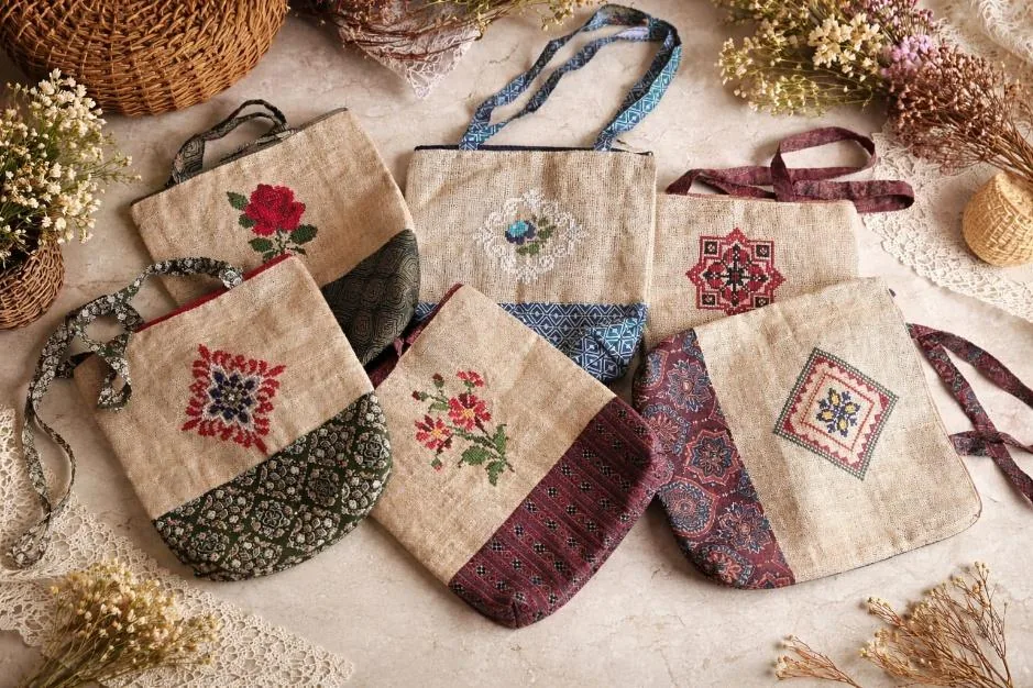 Jute bags with cross-stitch motifs and printed fabric panels