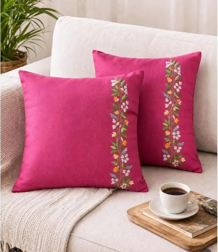 Pink cushion covers with a hand-embroidered floral band