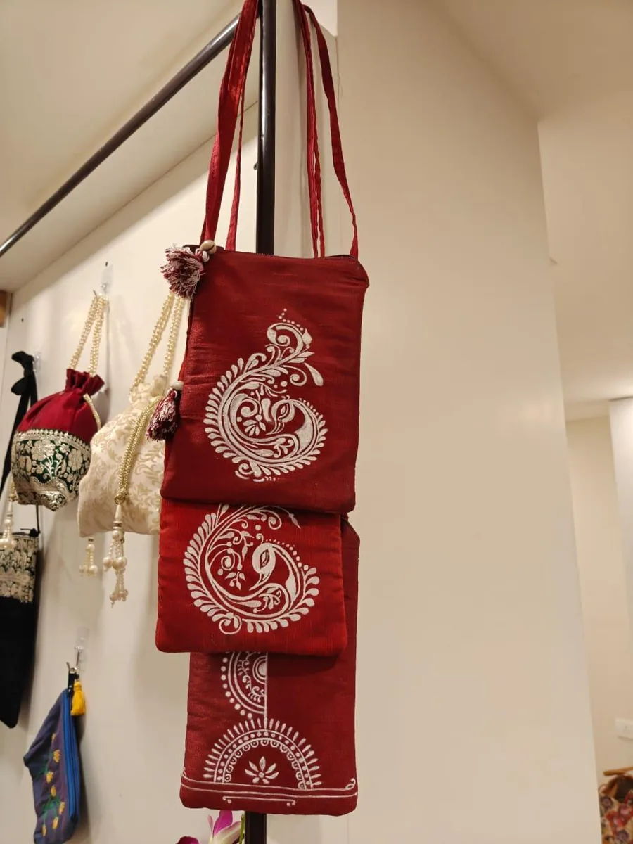 Red mobile sling bags with white paisley embroidery