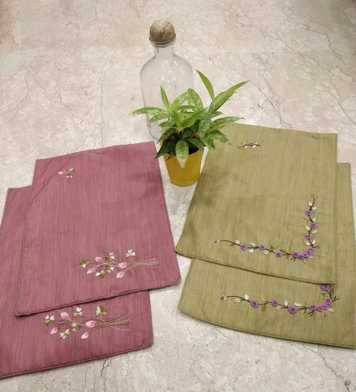 Pink and green table mats with embroidered sprigs