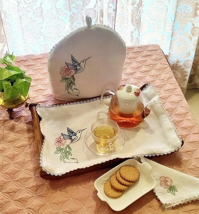 Tea cosy and tray cloth embroidered with a hummingbird